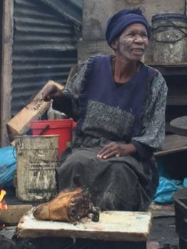 Kaapstad - Afrikaanse mama roostert schapenkop